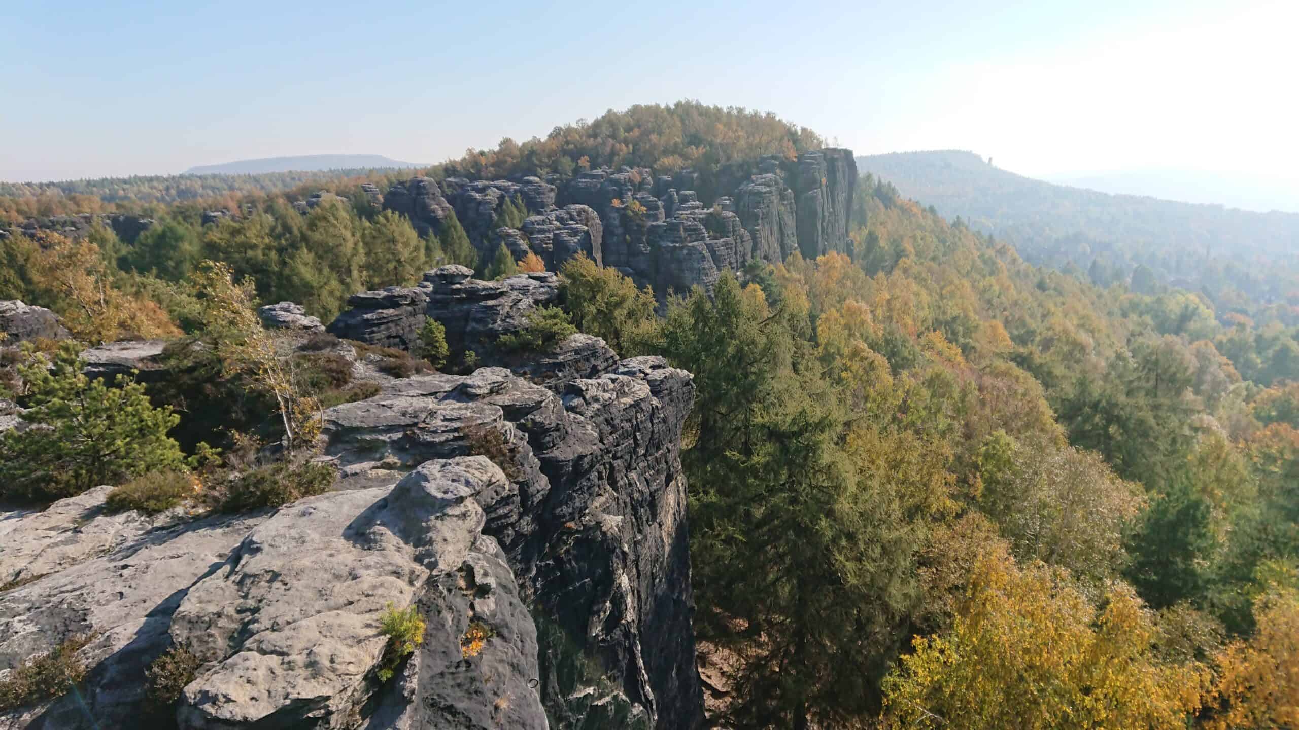 Výbor České asociace geomorfologů na skalnatém vyhlídkovém místě s výhledem na lesnaté údolí.